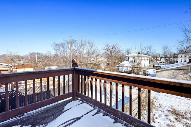 snow covered deck with a residential view