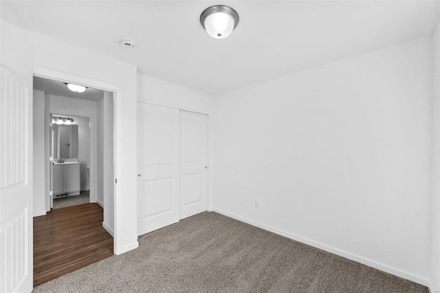 unfurnished bedroom featuring a closet and dark carpet