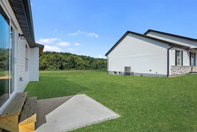 view of yard with central AC and a patio