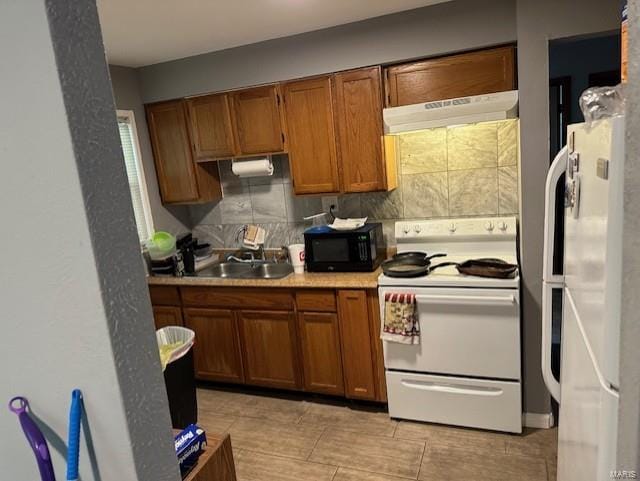 kitchen featuring sink, white appliances, and tasteful backsplash