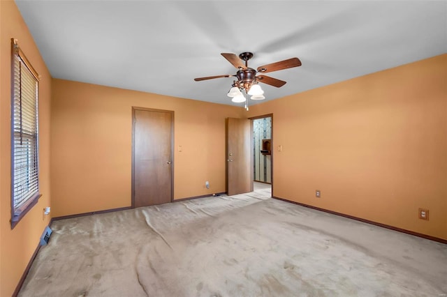 carpeted spare room featuring ceiling fan