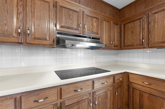 kitchen with black electric cooktop and tasteful backsplash