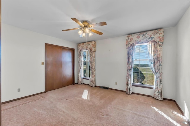 unfurnished room featuring ceiling fan and light colored carpet