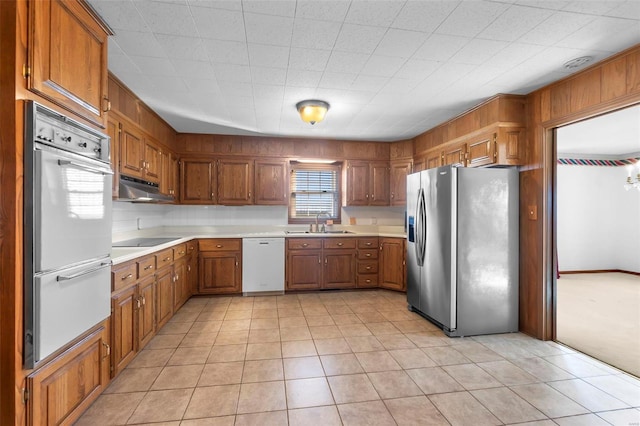 kitchen with sink, white appliances, and light tile patterned flooring