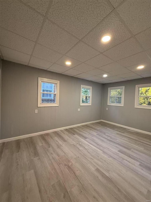 basement featuring light hardwood / wood-style floors and a drop ceiling