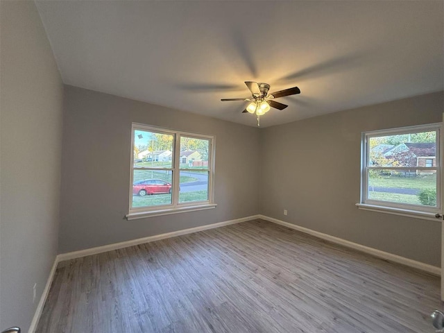 empty room with ceiling fan and light wood-type flooring