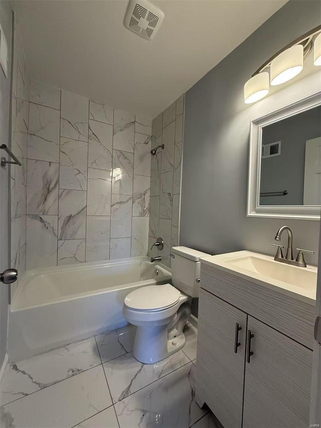 full bathroom with toilet, vanity, and tiled shower / bath