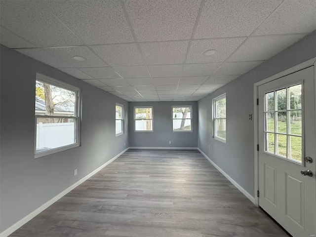 unfurnished room featuring hardwood / wood-style floors and a paneled ceiling