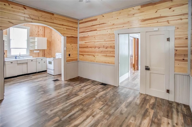 interior space featuring hardwood / wood-style flooring, sink, and wood walls