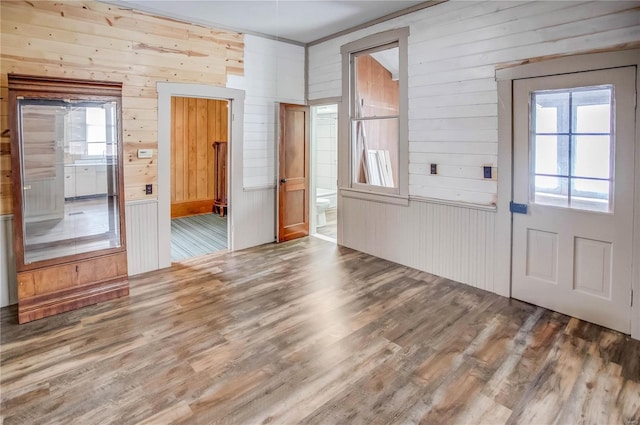 foyer entrance with hardwood / wood-style floors and wooden walls