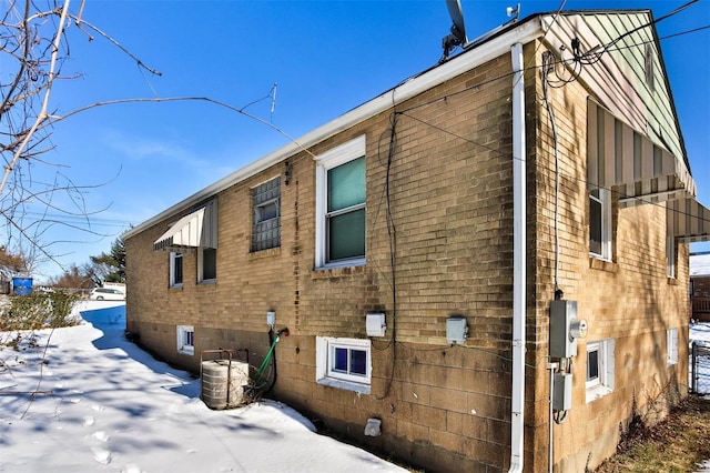 snow covered property with central AC unit