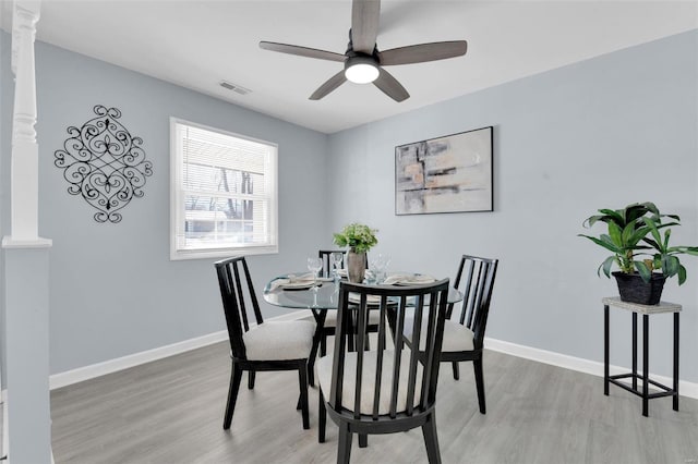 dining space featuring ceiling fan, light hardwood / wood-style floors, and ornate columns