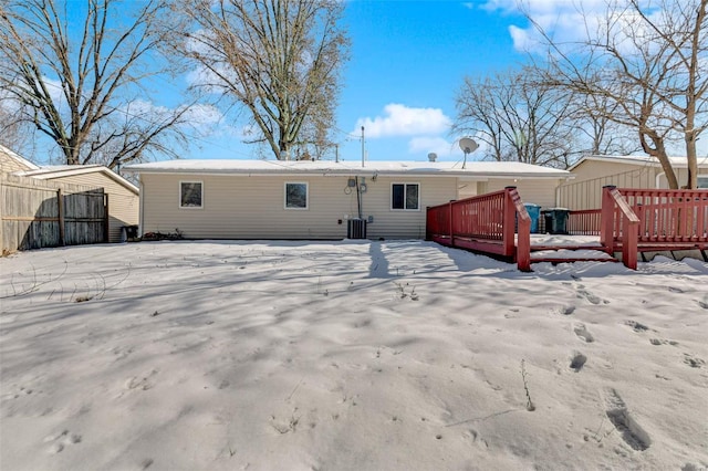 snow covered back of property featuring central AC and a wooden deck