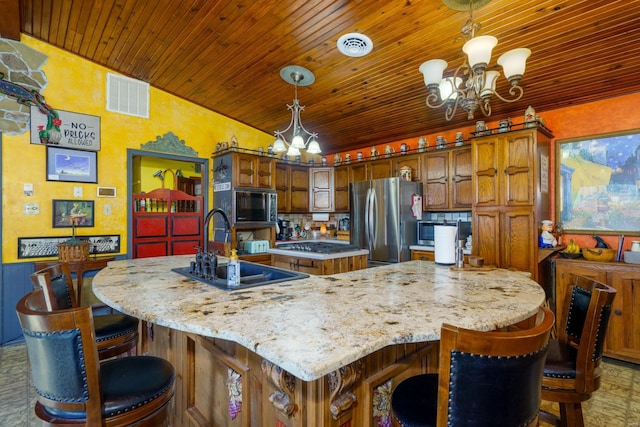 kitchen with a spacious island, hanging light fixtures, stainless steel appliances, and a chandelier