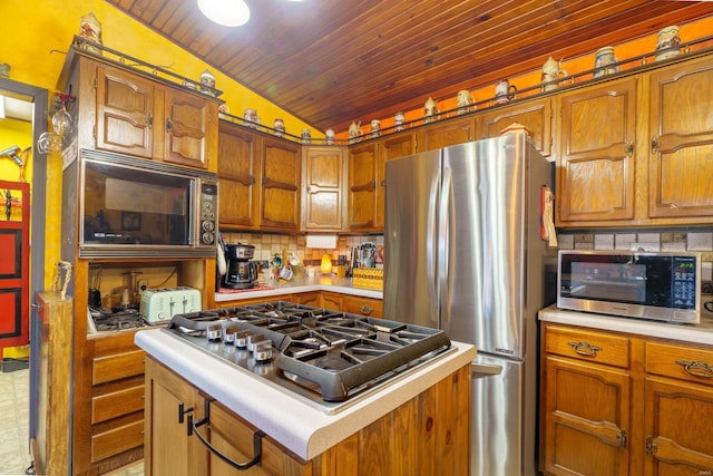 kitchen with appliances with stainless steel finishes, lofted ceiling, wood ceiling, a kitchen island, and decorative backsplash