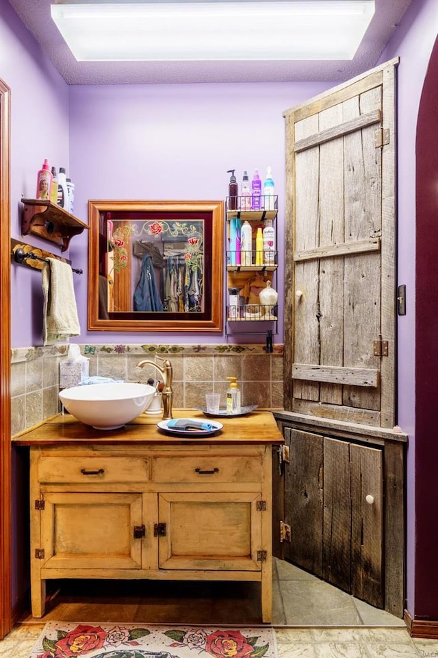 bathroom with vanity and tasteful backsplash