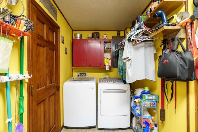 washroom with independent washer and dryer, a textured ceiling, and cabinets