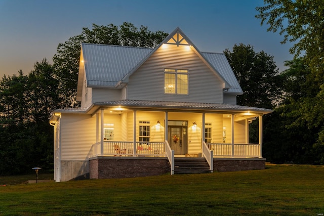 view of front facade featuring covered porch and a yard