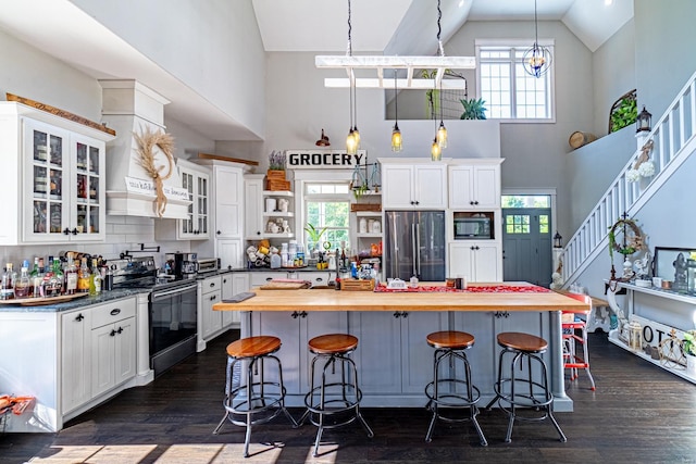 kitchen featuring a kitchen breakfast bar, stainless steel appliances, backsplash, and white cabinets