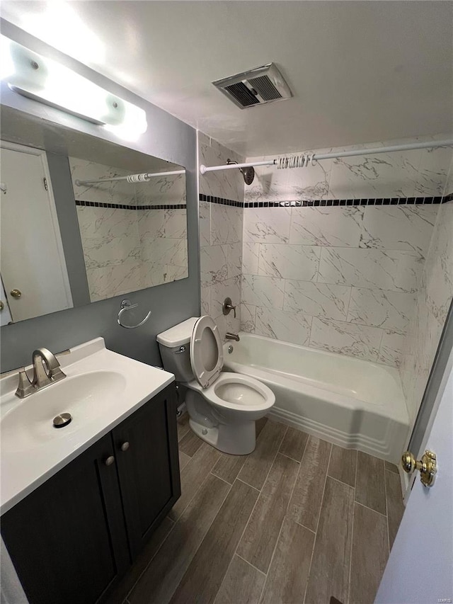 full bathroom featuring toilet, vanity, and tiled shower / bath