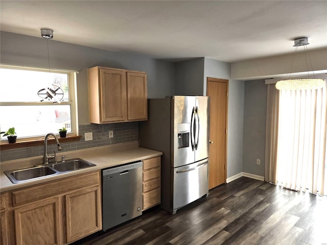 kitchen with backsplash, pendant lighting, sink, dark wood-type flooring, and appliances with stainless steel finishes