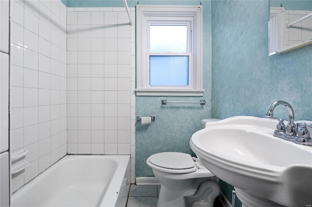 full bathroom with toilet, tiled shower / bath combo, tile patterned flooring, and sink