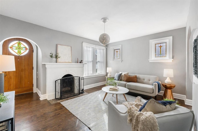 living room featuring a brick fireplace and dark hardwood / wood-style floors