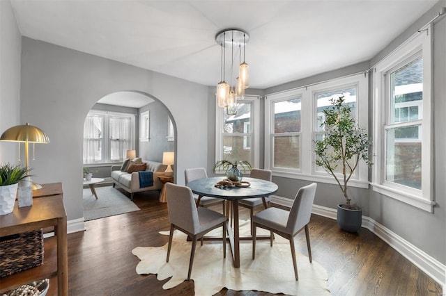 dining room with dark wood-type flooring and a chandelier