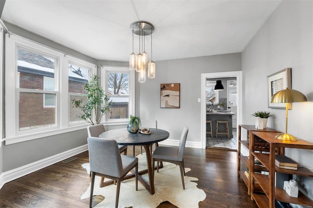 dining area featuring dark wood-type flooring and a chandelier