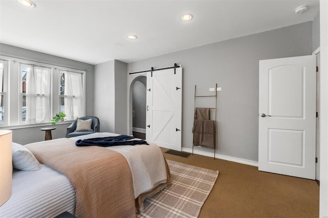 carpeted bedroom featuring a barn door