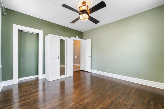 unfurnished bedroom with ceiling fan and dark wood-type flooring