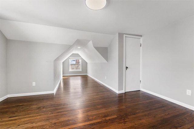 bonus room featuring vaulted ceiling and dark wood-type flooring