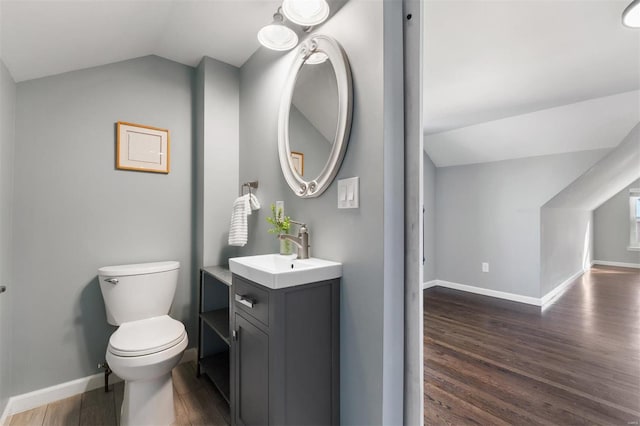 bathroom featuring lofted ceiling, vanity, toilet, and hardwood / wood-style floors