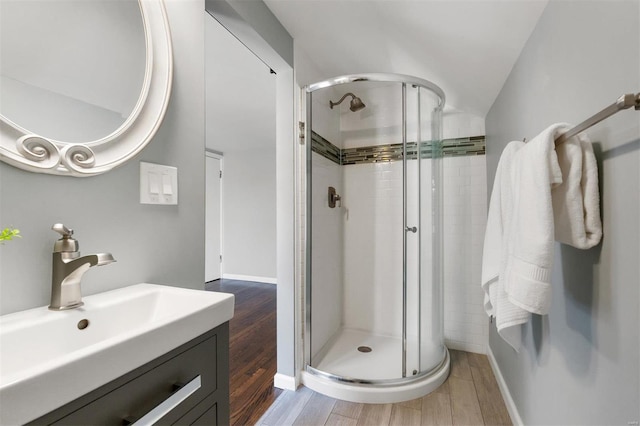 bathroom featuring wood-type flooring, an enclosed shower, and vanity