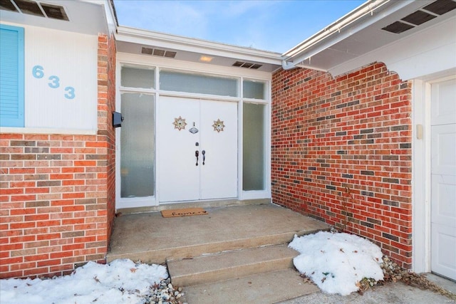 view of snow covered property entrance