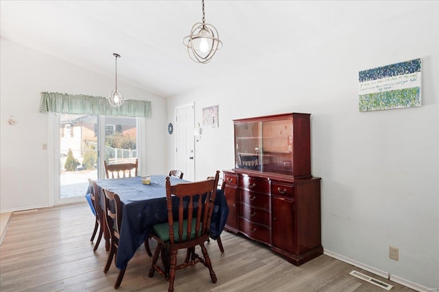 dining area featuring light hardwood / wood-style flooring and vaulted ceiling