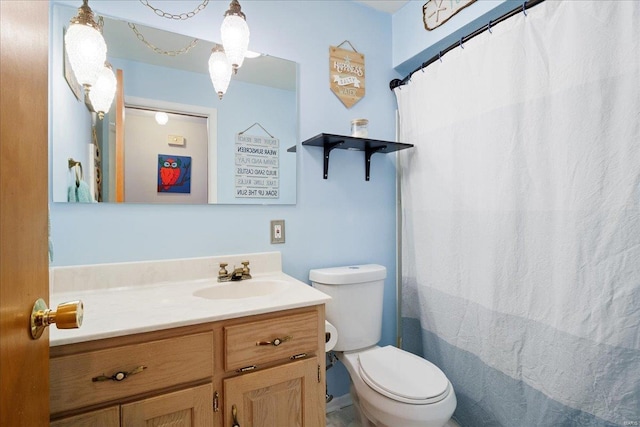 bathroom featuring toilet, vanity, and a shower with curtain