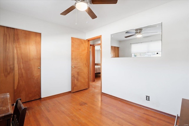 interior space with ceiling fan, a closet, and hardwood / wood-style flooring