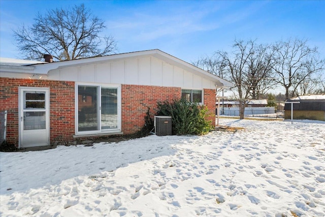 view of snow covered exterior with cooling unit