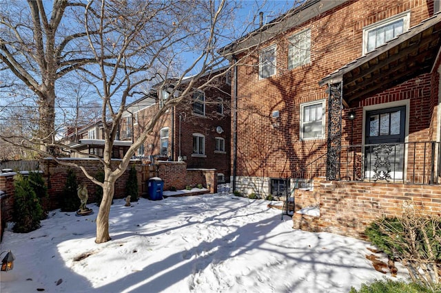 view of snow covered back of property