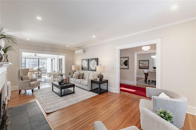 living room featuring light wood-type flooring, ornamental molding, and a wall mounted air conditioner