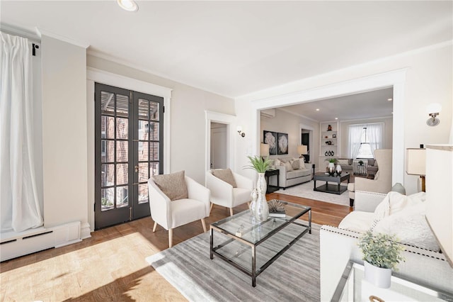 living room with a baseboard radiator, crown molding, french doors, and light wood-type flooring