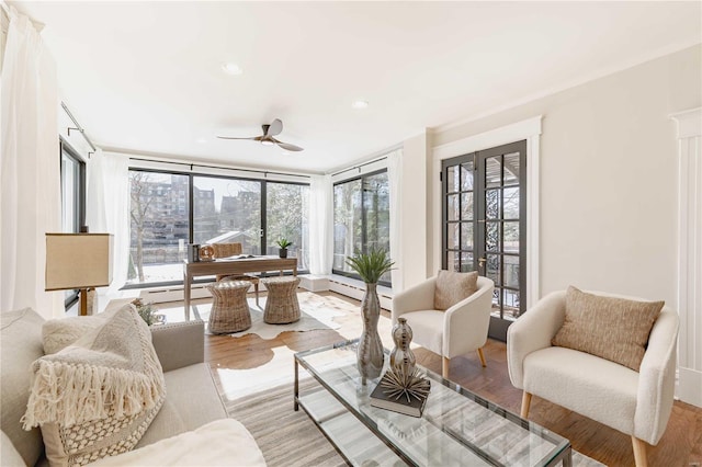 sunroom featuring a baseboard heating unit and ceiling fan