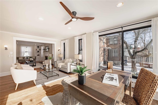 living room with ceiling fan, plenty of natural light, and hardwood / wood-style flooring