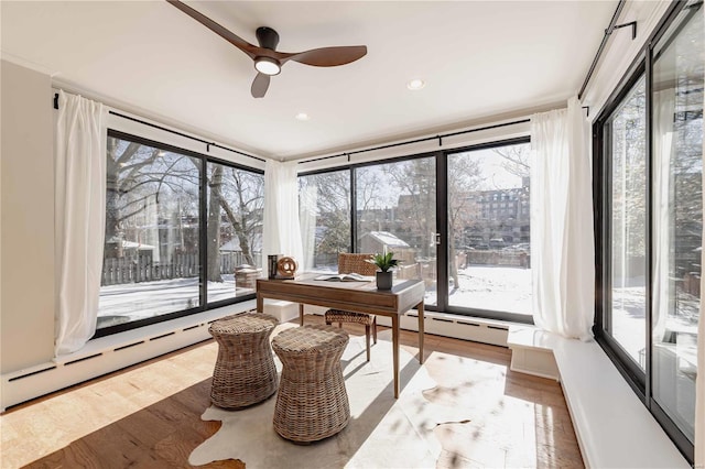 office area featuring ceiling fan, wood-type flooring, and a baseboard heating unit