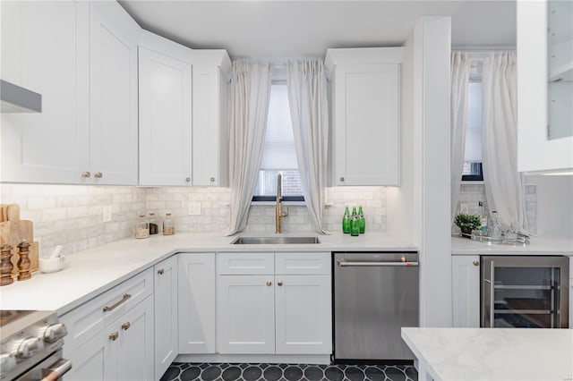 kitchen featuring sink, white cabinetry, appliances with stainless steel finishes, and beverage cooler