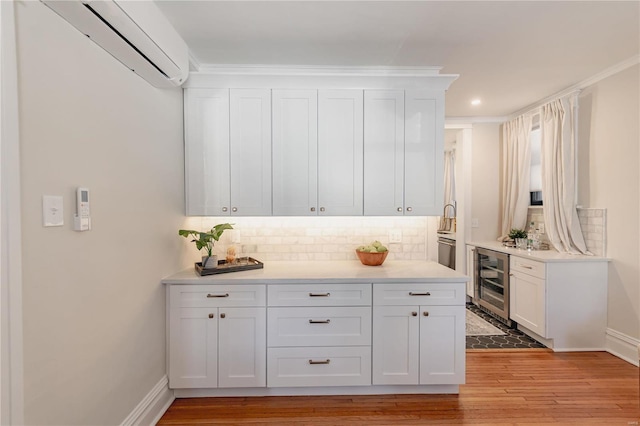 bar with white cabinetry, wine cooler, backsplash, light wood-type flooring, and a wall mounted air conditioner