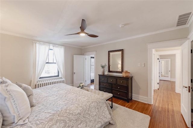 bedroom with ceiling fan, radiator, crown molding, and hardwood / wood-style floors