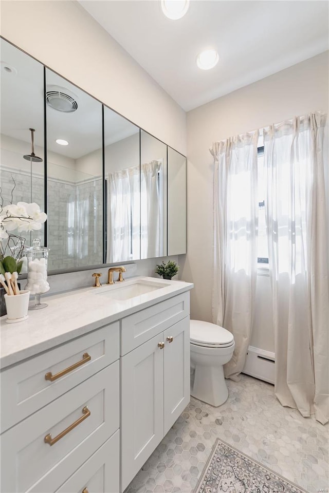 bathroom featuring a baseboard radiator, toilet, and vanity