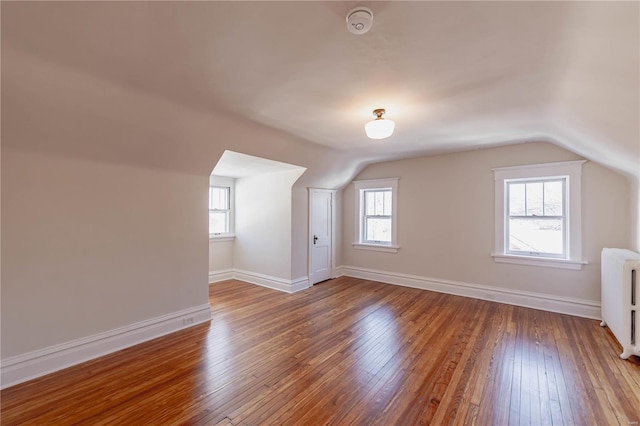 bonus room featuring hardwood / wood-style flooring, radiator, and vaulted ceiling